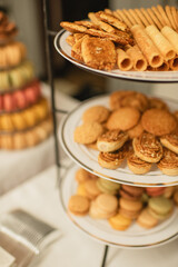 Tiered tray with assorted cookies, wafers, and colorful macarons