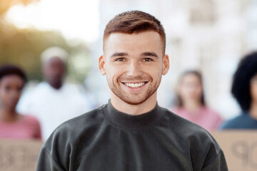 Cheerful guy standing over international group of protestors, smiling at camera, blurred...