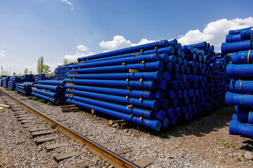 Stack of cast iron pipes in loading area waiting for transportation
