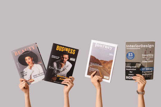 Female hands with different magazines on grey background