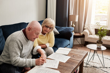 Couple, retirement and writing documents in home for planning budget, financial assets and sign...