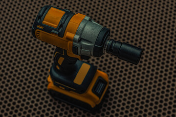 A powerful cordless impact wrench on a floor. Electric tool for construction and automotive repair.