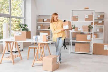 Fototapeta premium Female seller with parcel box in online store warehouse