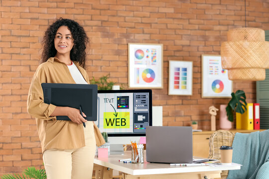 Female African-American web designer with graphic tablet in office