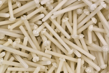 White plastic nylon screws scattered hardware work tools accessories computer components.