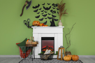 Fireplace decorated for Halloween near green wall in living room
