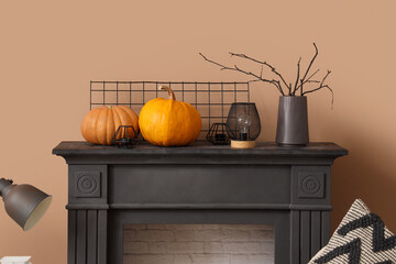 Black fireplace, pillow and pumpkins in autumn living room, closeup