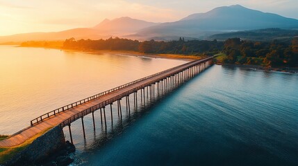 Sunrise over a long wooden bridge across tranquil water.