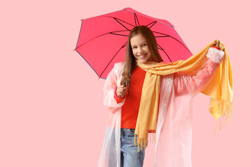 Cute teenage girl in raincoat with umbrella on pink background