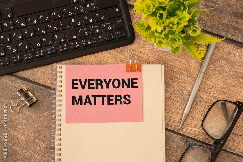 Poster everyone matters text on the notebook with office background