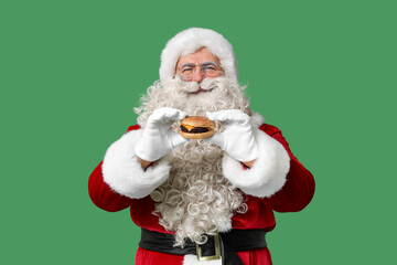 Santa Claus with tasty burger on green background