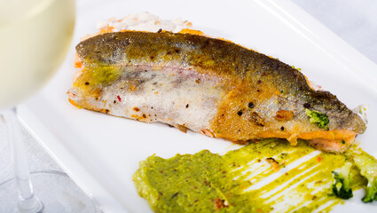 Delicious fried rainbow trout fillets with tartare sauce and broccoli puree served with white wine
