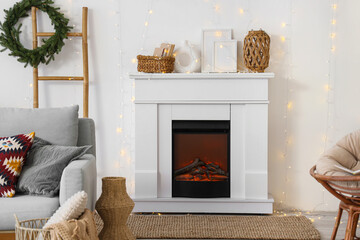 Interior of festive living room with fireplace, Christmas wreath and glowing lights