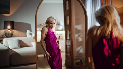 Flirting blonde looking mirror in dress. Dancing model getting ready for party