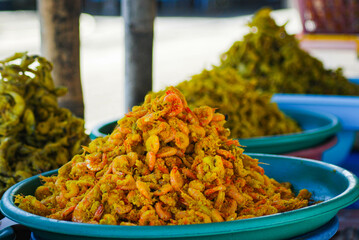 piles of seafood, crispy dried shrimp on a woven bamboo container, coastal area culinary stalls serving lots of delicious seafood specialties
