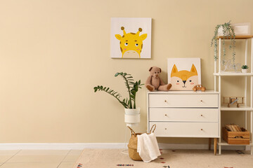 Interior of nursery with commode, shelf unit and pictures
