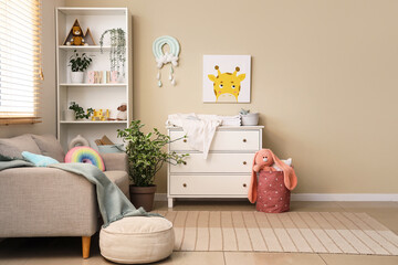 Obraz premium Interior of nursery with commode, shelf unit and sofa