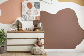 Interior of nursery with commode, painting and toys