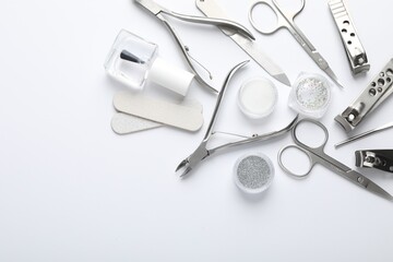 Set of different manicure tools on white background, flat lay. Space for text