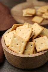 Tasty salty crackers on wooden table, closeup