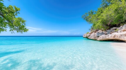 Fototapeta premium Pristine turquoise waters meet pristine white sand beach, framed by lush tropical foliage