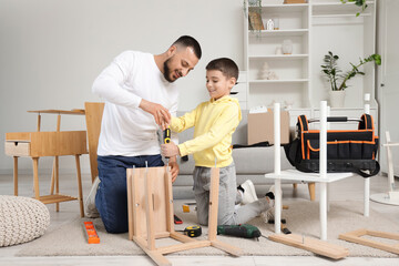 Father with his son assembling stool at home