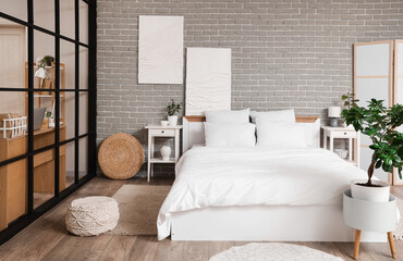 Interior of studio apartment with folding screen, bed and tables