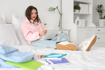 Female Indian student studying with laptop in bedroom