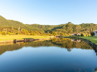 Calm reflective water of waterway through idyllic landscape