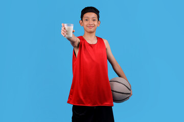 Young boy in red uniform holding a ball and milk, promoting health and activity.