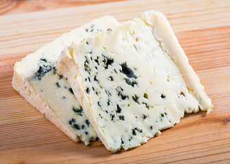 Image of slices of blue cheese with mold at plate, nobody