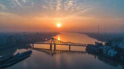 Obraz premium aerial view of a long bien bridge spanning the red river under a vibrant sunrise in hanoi vietnam showcasing urban landscape and serene waters with reflections and soft light