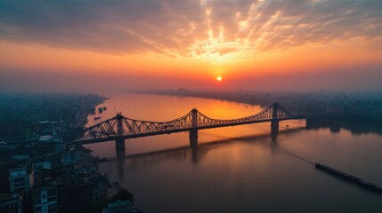 Fototapeta premium an aerial view capturing a majestic bridge spanning a serene river during a vibrant sunrise