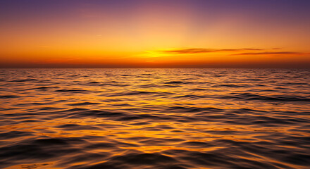 Obraz premium Golden Hour Seascape: Sunset's Fiery Embrace on Calm Waters