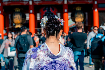 Fototapeta premium Young girl wearing Japanese kimono standing in front of Sensoji Temple in Asakusa Tokyo, Japan. Kimono is a Japanese traditional garment.