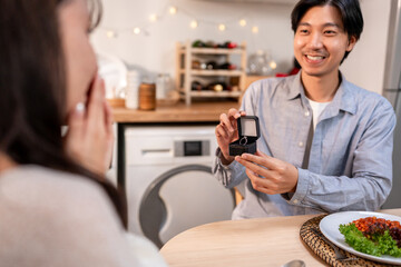 Asian romantic man surprise his girlfriend with a marriage proposal. 