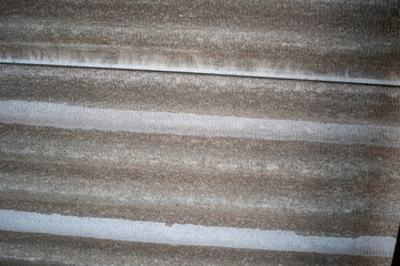 Worn, corrugated gray roofing material texture with subtle ridged patterns and weathered look concept.
