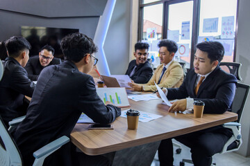 Group of young business people working and communicating while sitting at the office desk together