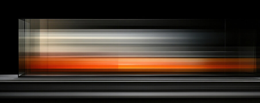 A blurry image of a train with orange and white stripes. The train is moving and the stripes are fading into the background. The image has a sense of motion and energy