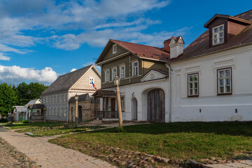 View of historical merchant buildings of estates on the main street of Izborsk Pechorskaya Street on a summer sunny day, Izborsk, Pskov region, Russia