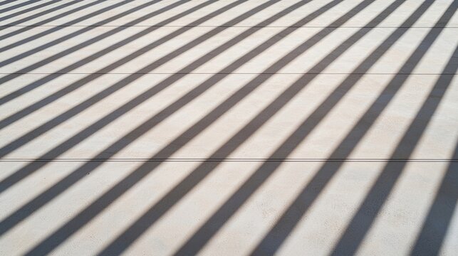 Parallel shadows create a striped pattern on a flat, light-colored surface in sunlight.