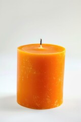 A bright orange candle stands upright on white background, ideal for ambiance and decor.
