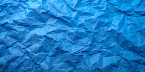 A blank, rough sheet of crumpled blue paper shows a wrinkled texture and creased pattern