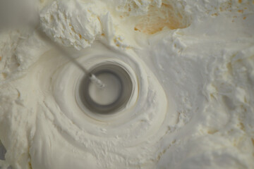Cream being whipped to perfection in a mixing bowl during preparation
