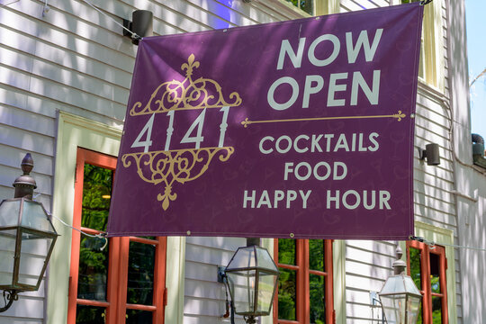 New Orleans, LA, USA - April 18, 2025: Front of 4141 Bar with Banner Saying "Now Open: Cocktails, Food, Happy Hour;" at 4141 St. Charles Avenue in Uptown Neighborhood