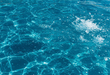 Fototapeta premium Closeup of clear blue water in sea or river. Shiny waves of clean blue sea water over a sandy beach, for a beautiful summer time background.