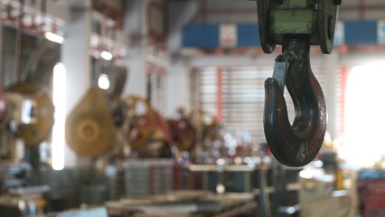 Closeup of swivel chain hook crane of electric hoist in factory workshop, pullersSwivel chain hook...