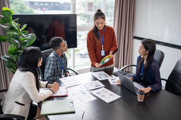 Asian business woman Application Designers presenting trending products report mobile application...