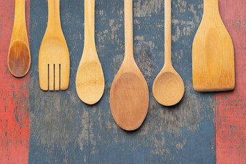 Assorted Wooden Kitchen Utensils on a Rustic Painted Wooden Background. File with Clipping Path.