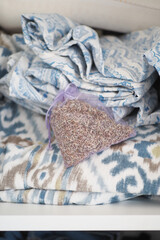 Lavender sachet resting on folded fabric in a cozy storage nook